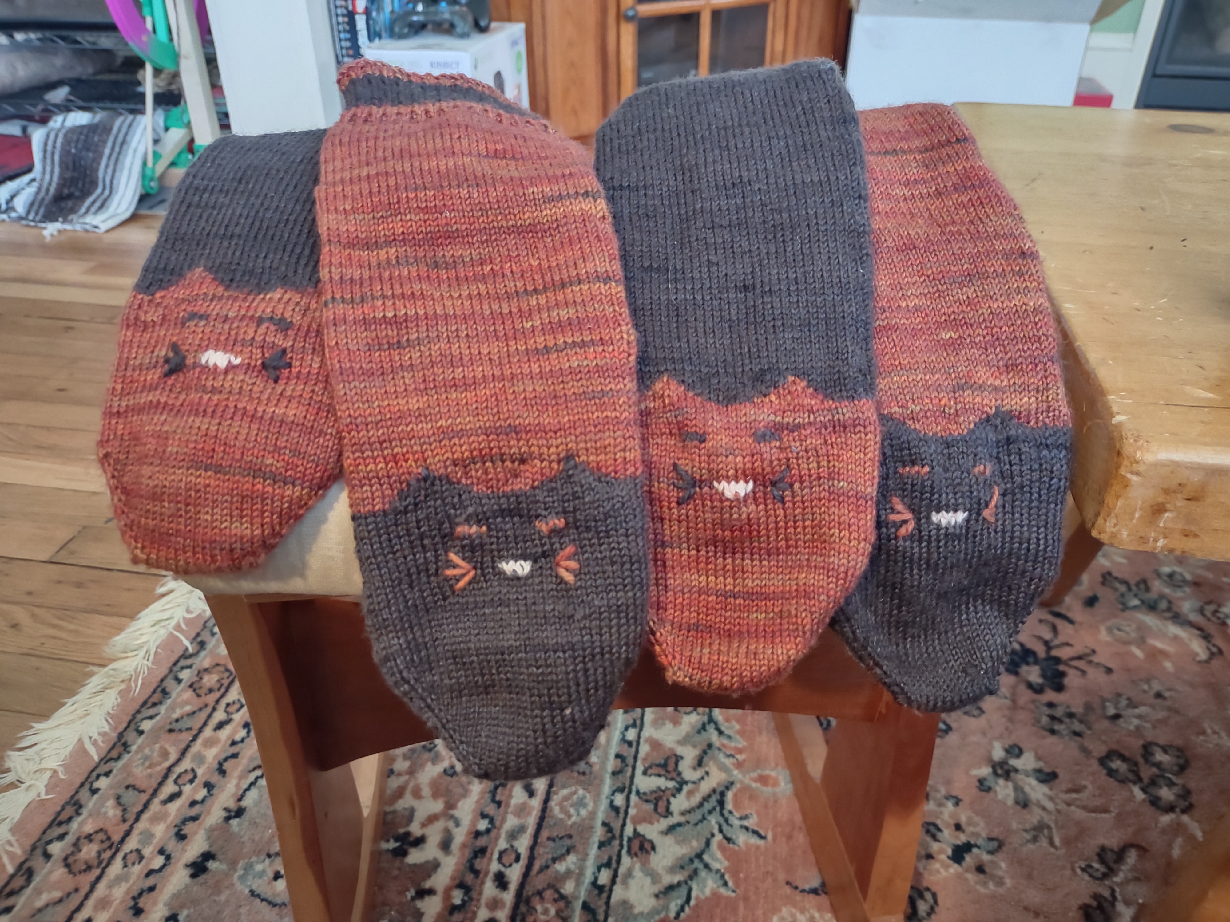 two pairs of socks that have cat faces on the toe