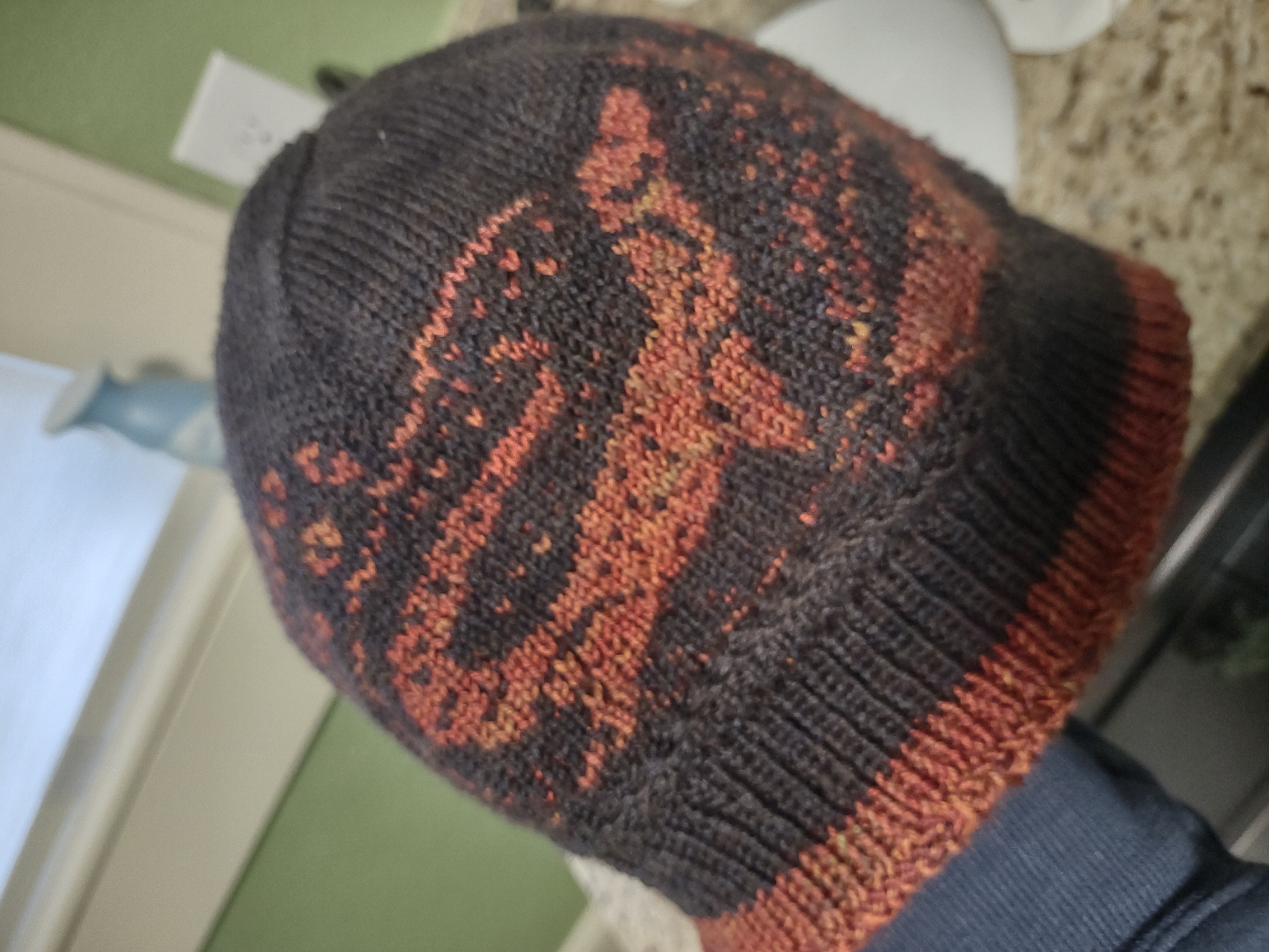 a black and orange hat with lizard colorwork